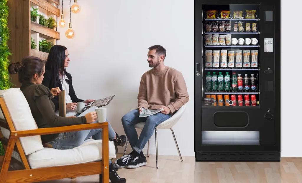 Collègues en pause près d'un distributeur Snack SAPHIRH dans un salon d'entreprise